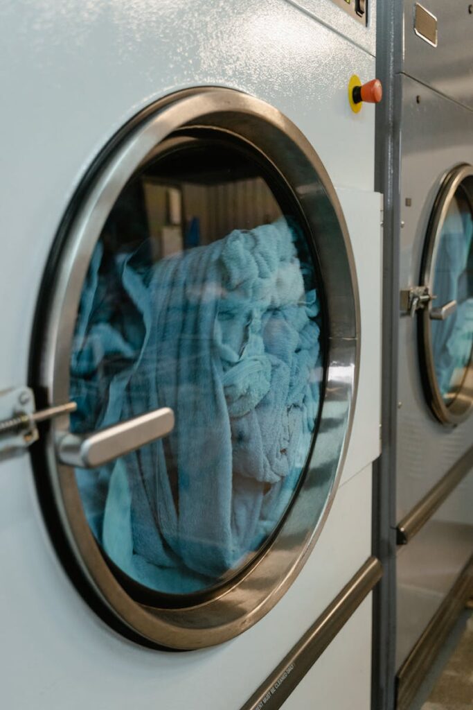 Close-up of an industrial laundry machine with blue towels inside, highlighting automated service.