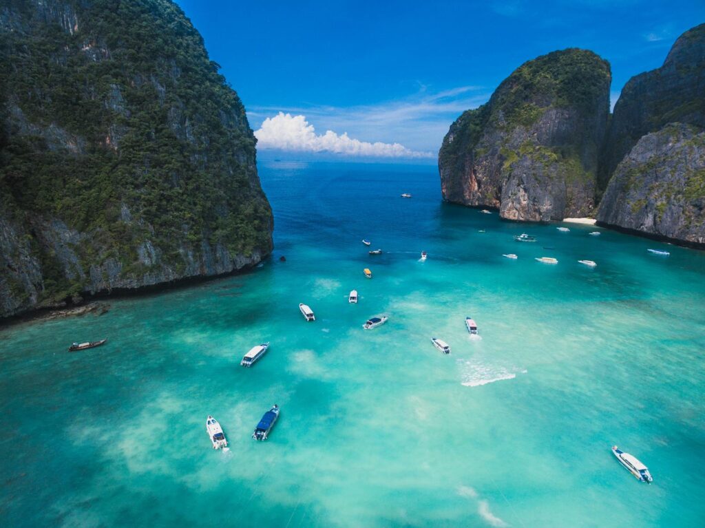 Aerial view of a picturesque tropical bay with boats and turquoise waters, ideal for travel and leisure.